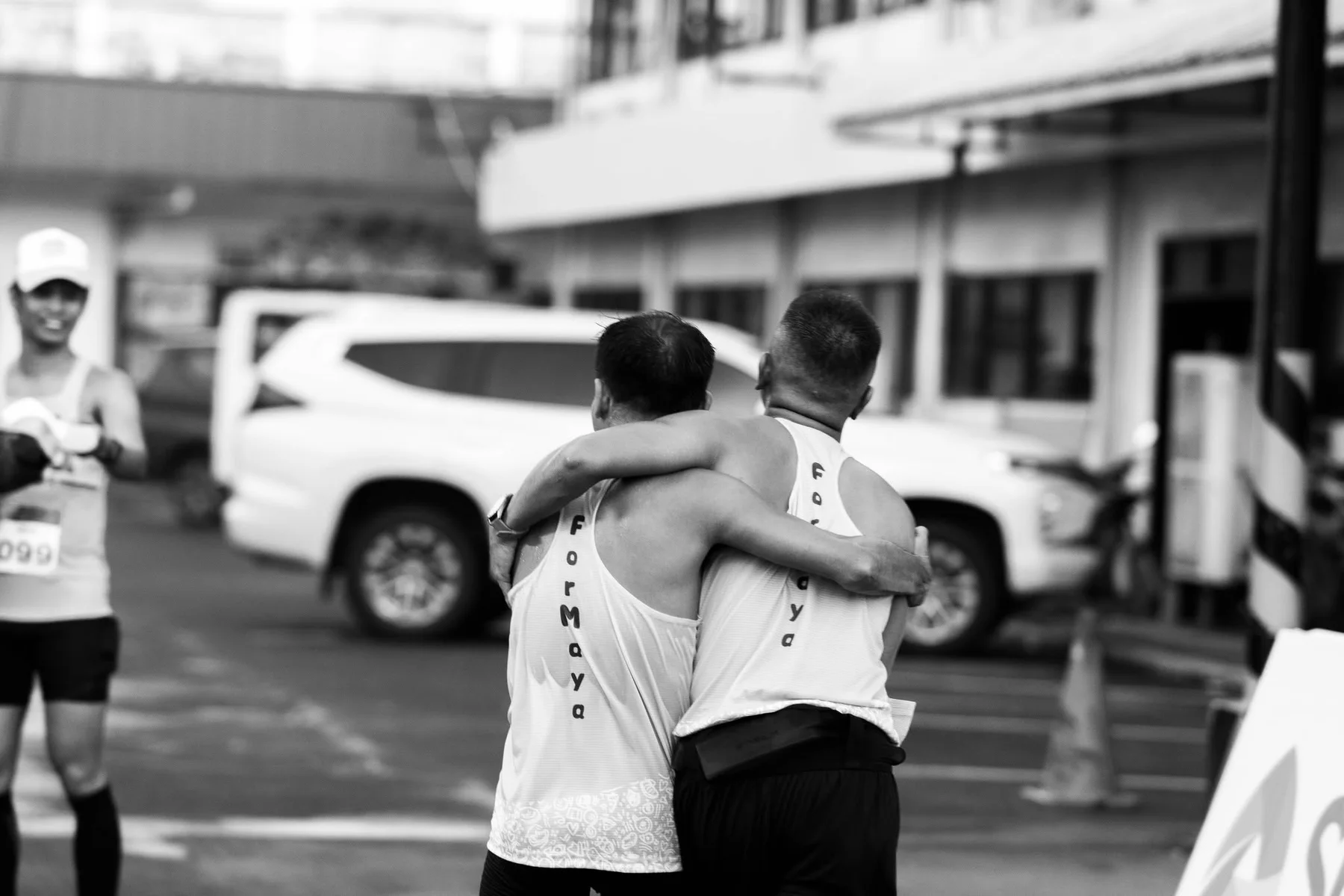 Two runners walking together with their arms around each other