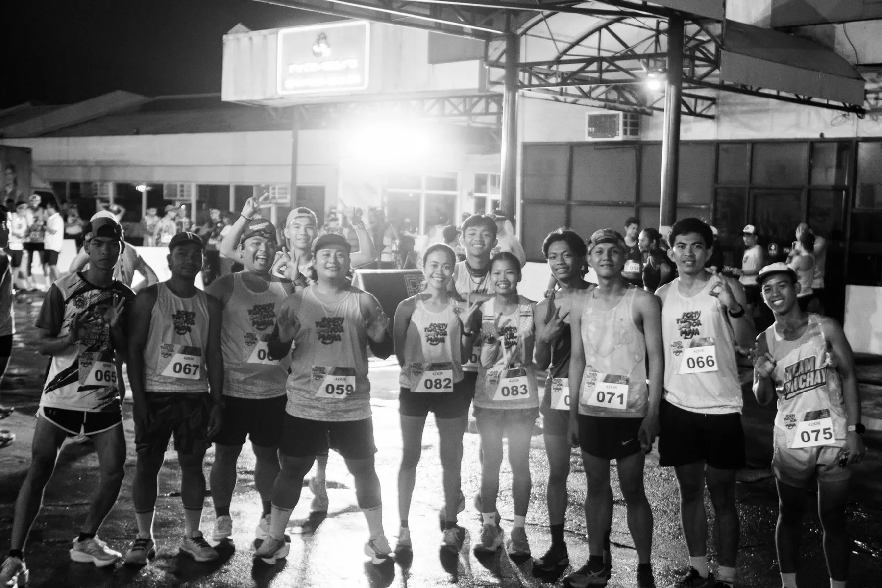 A group of runners gathered together at the start in black and white